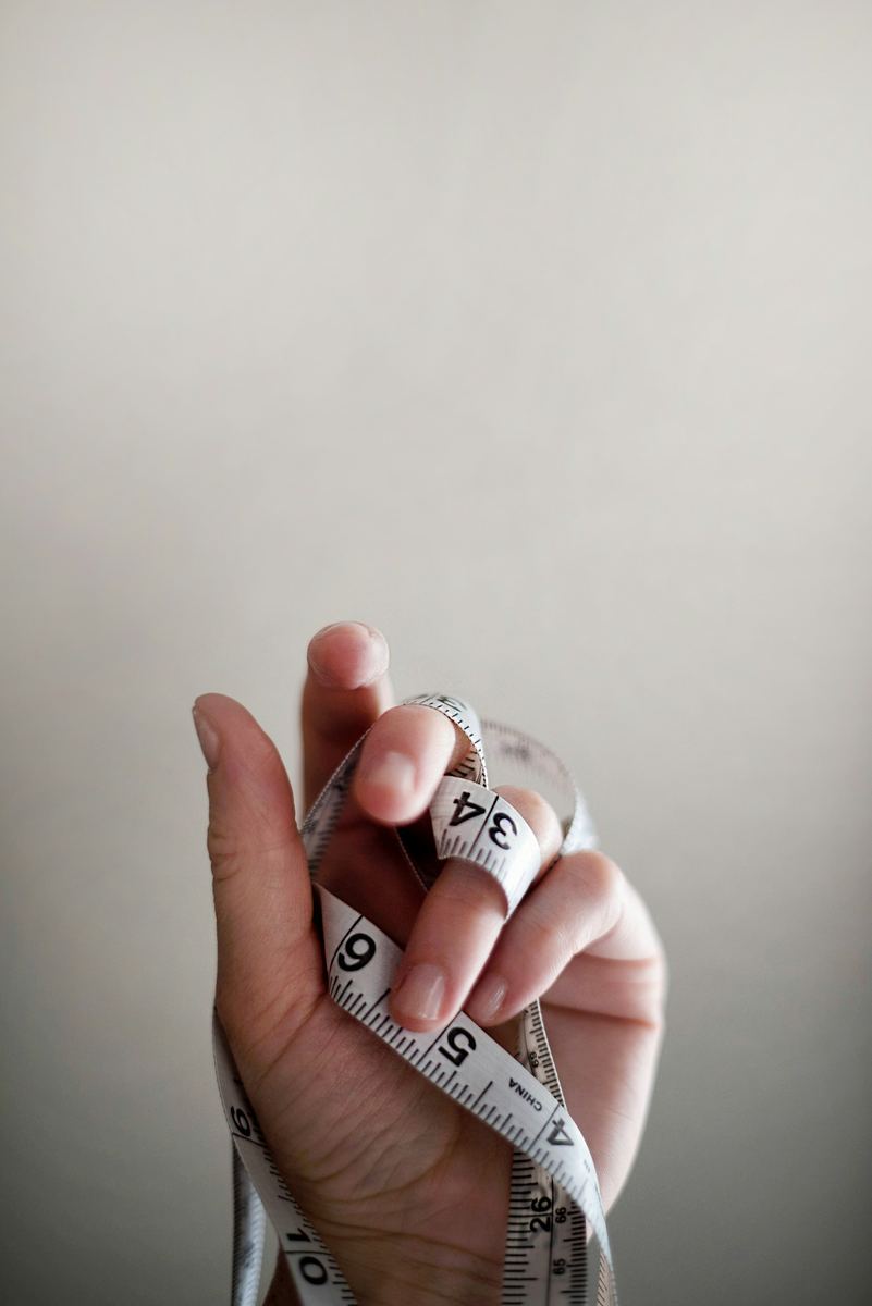 Hand holding a rolled soft measuring tape